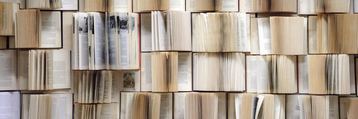 Wand voller aufgeklappter Bücher