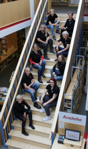 Bibliotheksteam, auf Treppe sitzend